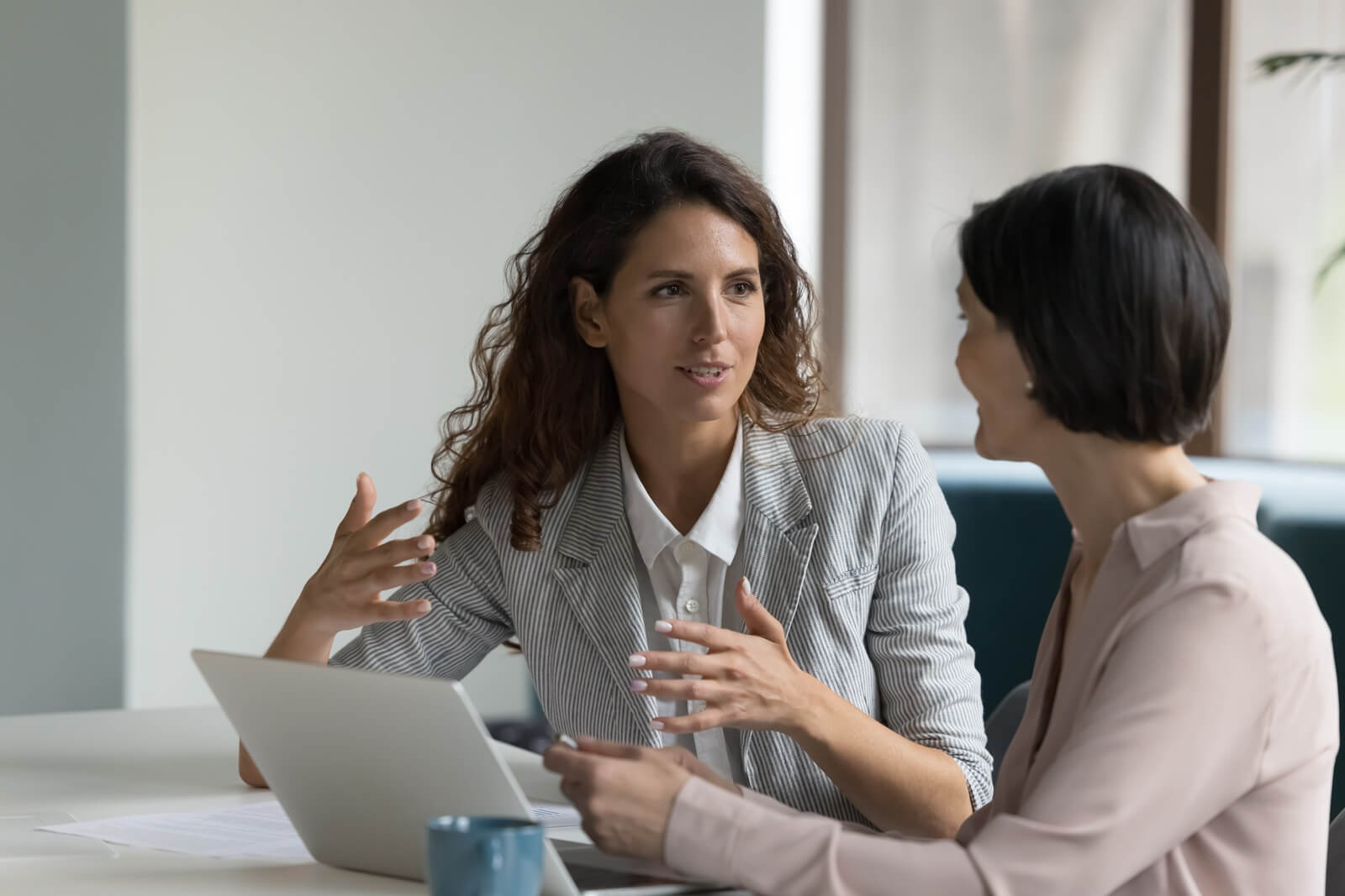business women sit at desk discuss project details