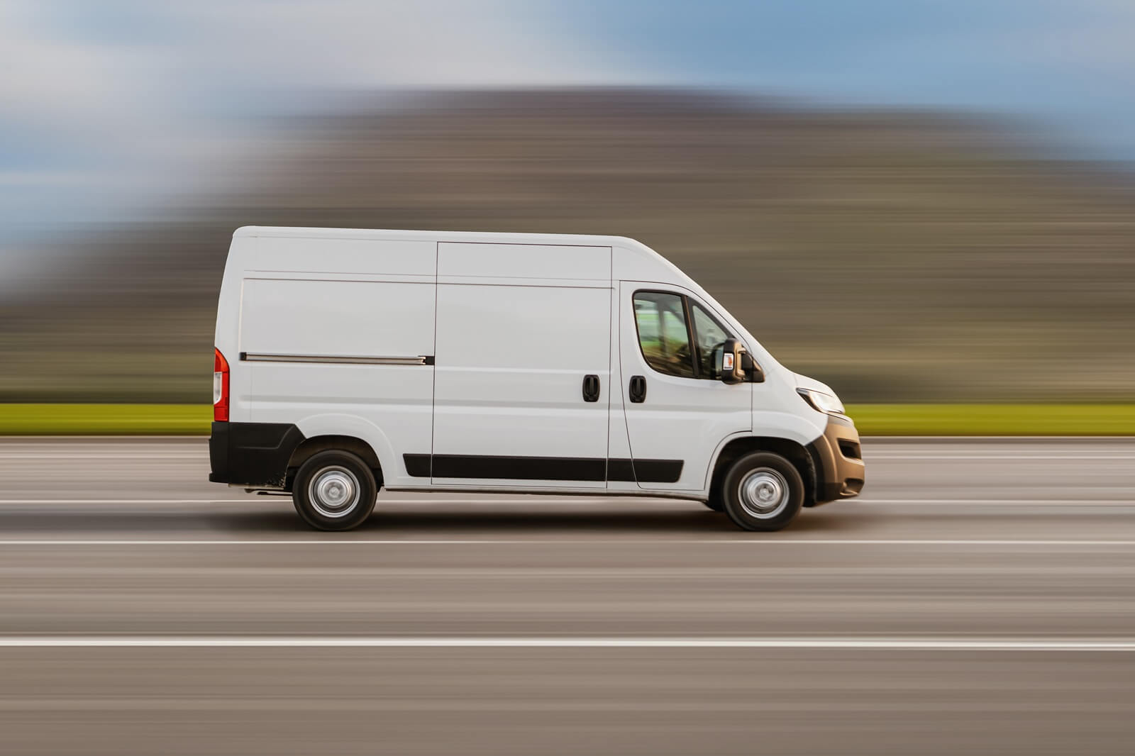 cargo van is driving on the highway at speed with a blurred background