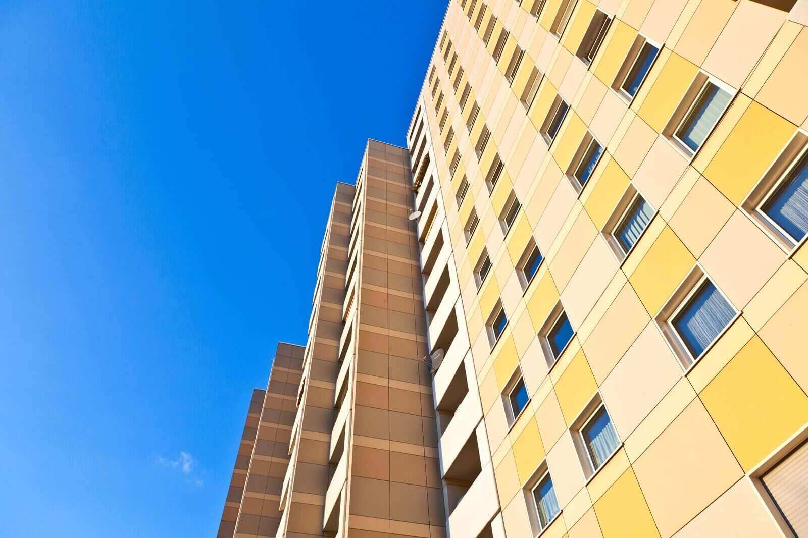 facade of skyscraper with apartments with blue sky