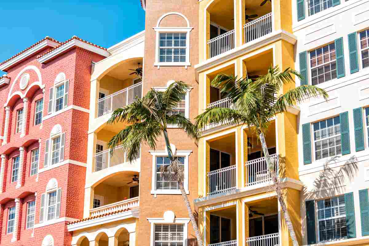 Condos, condominiums colorful, orange yellow multicolored buildings facade exterior with windows, palm trees, real estate property in connecticut