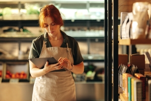 Retail Store Owner Checking Insurance Coverages on Tablet