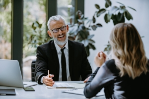 Senior Insurance Agent Explaining Workers Compensation Coverage to Business Owner