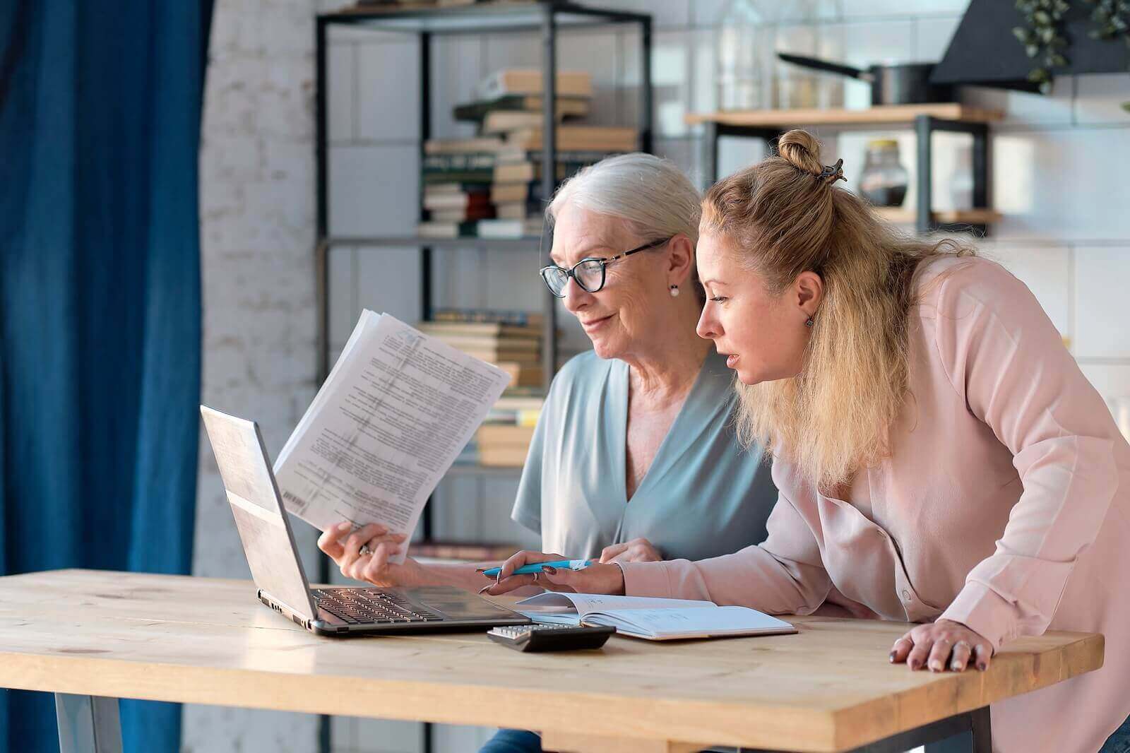 senior woman using laptop for websurfing in her kitchen