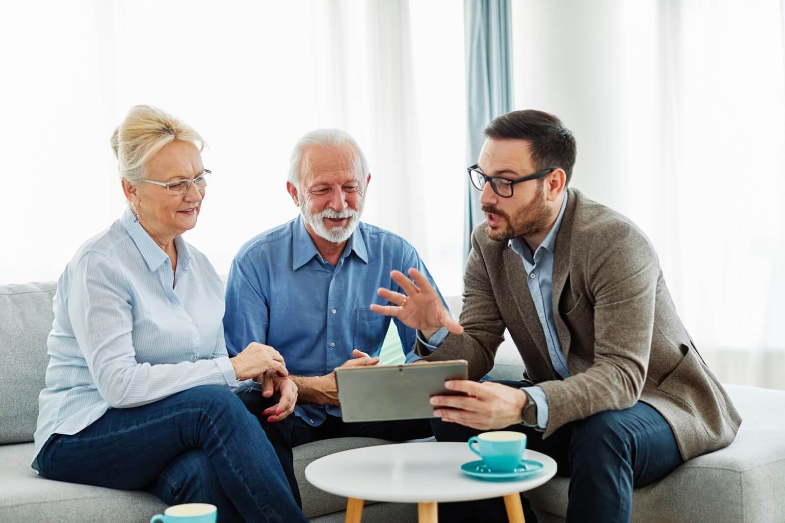 seniors couple having a meeting with an agent, businessman, salesperson or doctor in his offices
