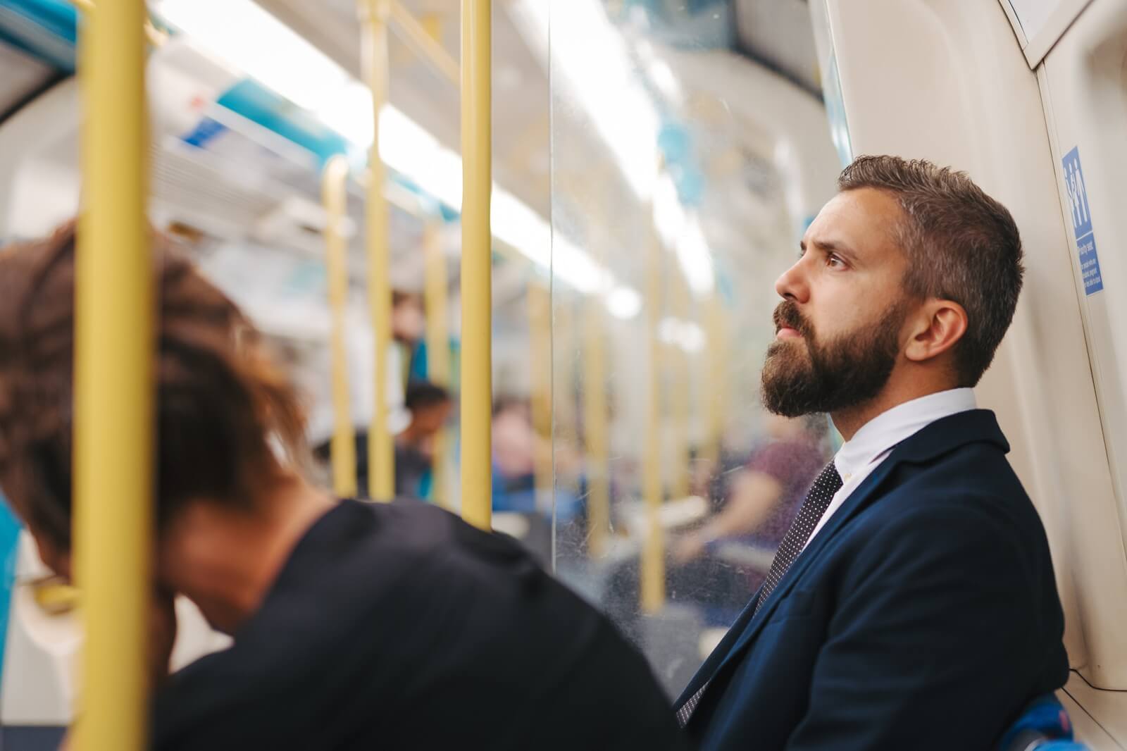side view of man sitting in subway train