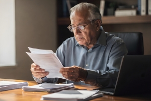 Senior Man Gathering Documents for His Old Home Insurance