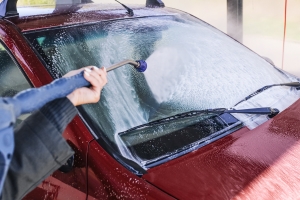 Home Car Wash Service Worker Washing Red Car with Pressure Washer