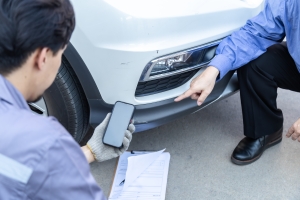 Insurance Agent Inspecting Damage on Vehicle for Claim Process