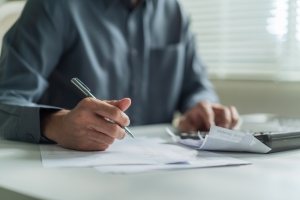 Landscaping Company Owner Reviewing Workers Compensation Insurance Policy to Manage Costs